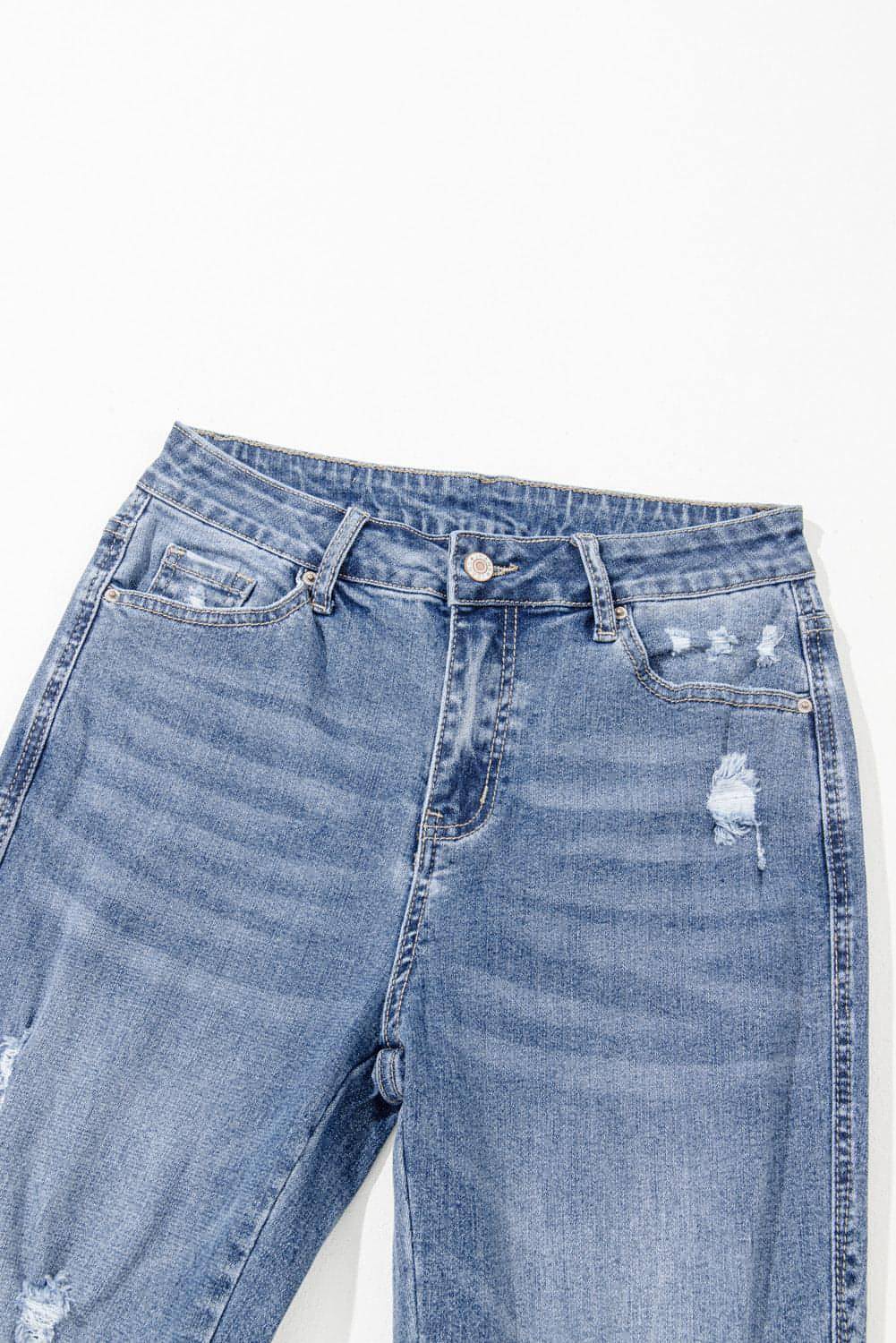 Dusk blue high-rise flared jeans with ripped distressed hem by Carmine Juneberry, showcasing fashionable denim style