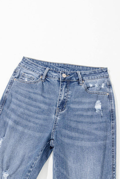 Dusk blue high-rise flared jeans with ripped distressed hem by Carmine Juneberry, showcasing fashionable denim style