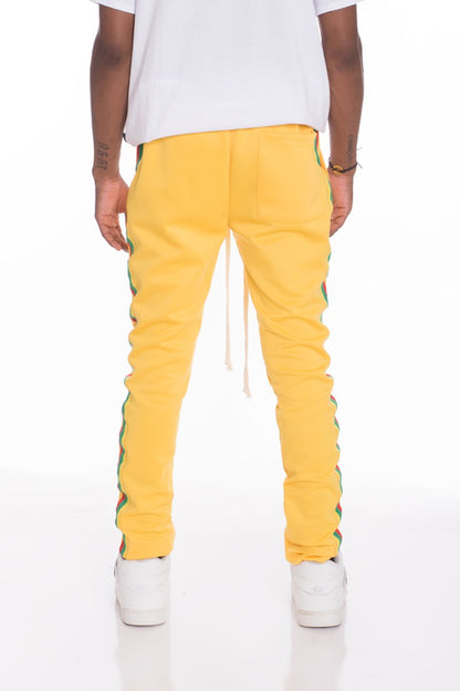 Yellow Rasta Track Pants by Lime Milo featuring bold Rasta-inspired design and comfortable fit, shown on a model.