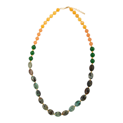 Patagonia green chrysocolla and golden long necklace with intricate bead details, styled with a person wearing a white shirt.
