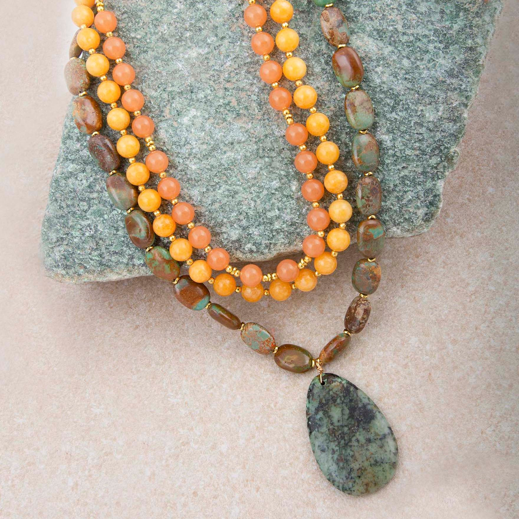 Green Chrysocolla pendant on a gold necklace, elegant jewelry piece with vibrant green and blue hues, stylish and handcrafted.
