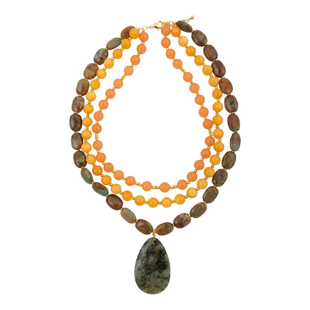 Green Chrysocolla pendant on a gold necklace, jewelry featuring a polished stone with vibrant green and blue tones.