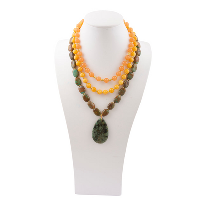 Green Chrysocolla pendant on a gold necklace, jewelry piece with vibrant green stone and elegant chain design.