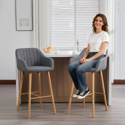 Modern linen upholstered bar stool with back, armrests, footrest, and solid wood legs, designed for stylish furniture interiors.