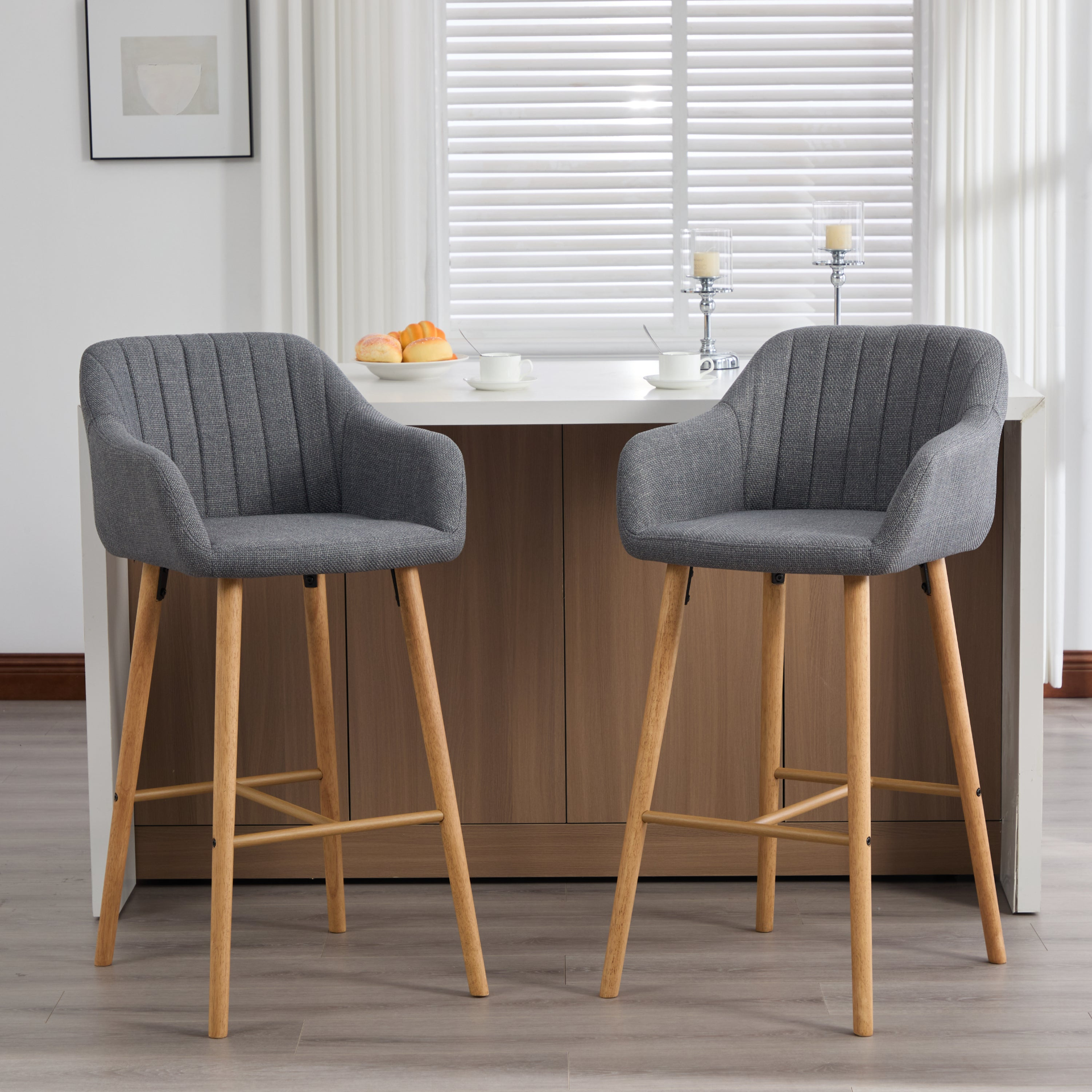 Modern linen upholstered bar stool with back, armrests, footrest, and solid wood legs, designed for stylish kitchen or bar area.