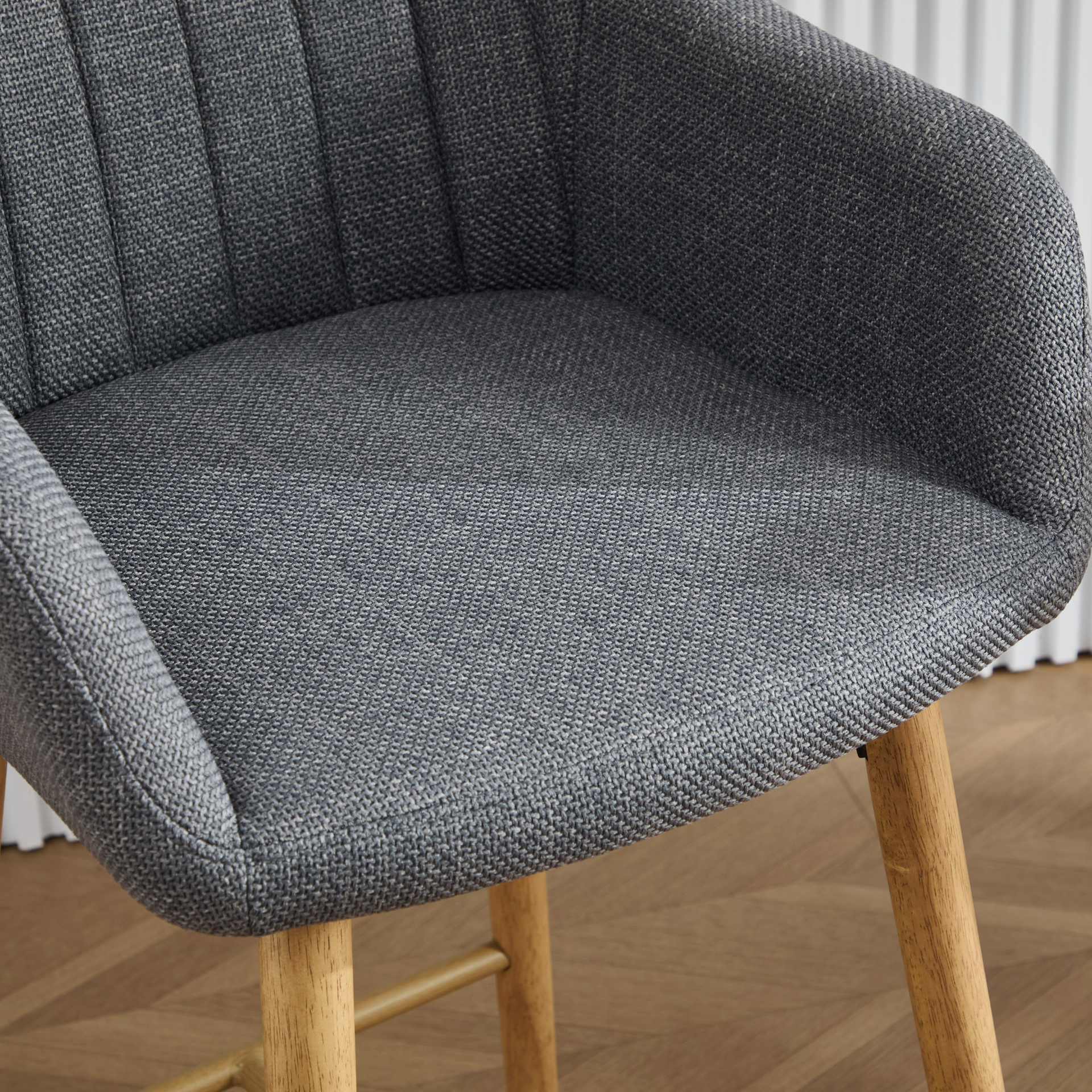 Modern linen upholstered bar stool with back, armrests, footrest, and solid wood legs, ideal for contemporary furniture style.
