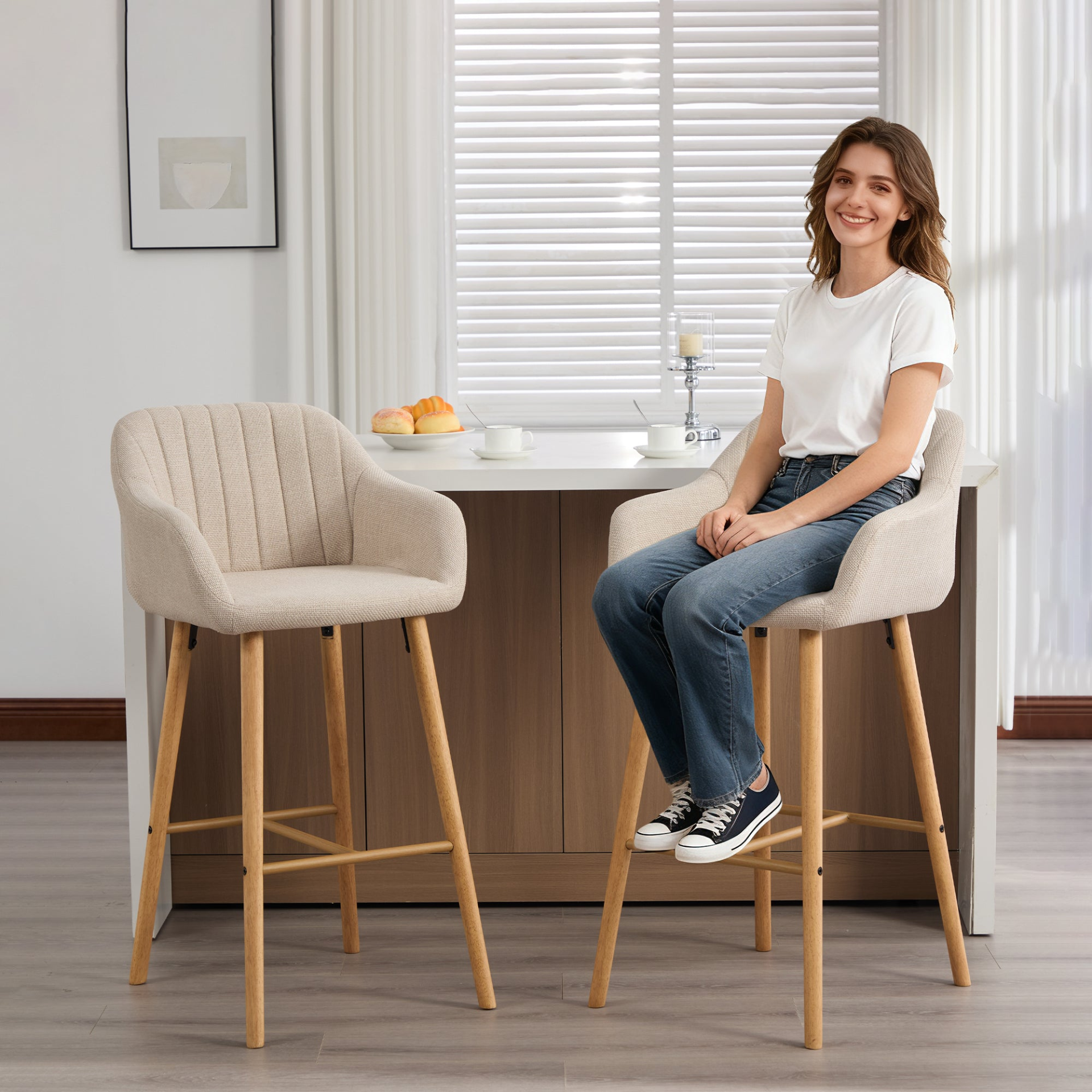Modern linen upholstered bar stool with back, armrests, footrest, and solid wood legs, designed for stylish kitchen or bar seating.