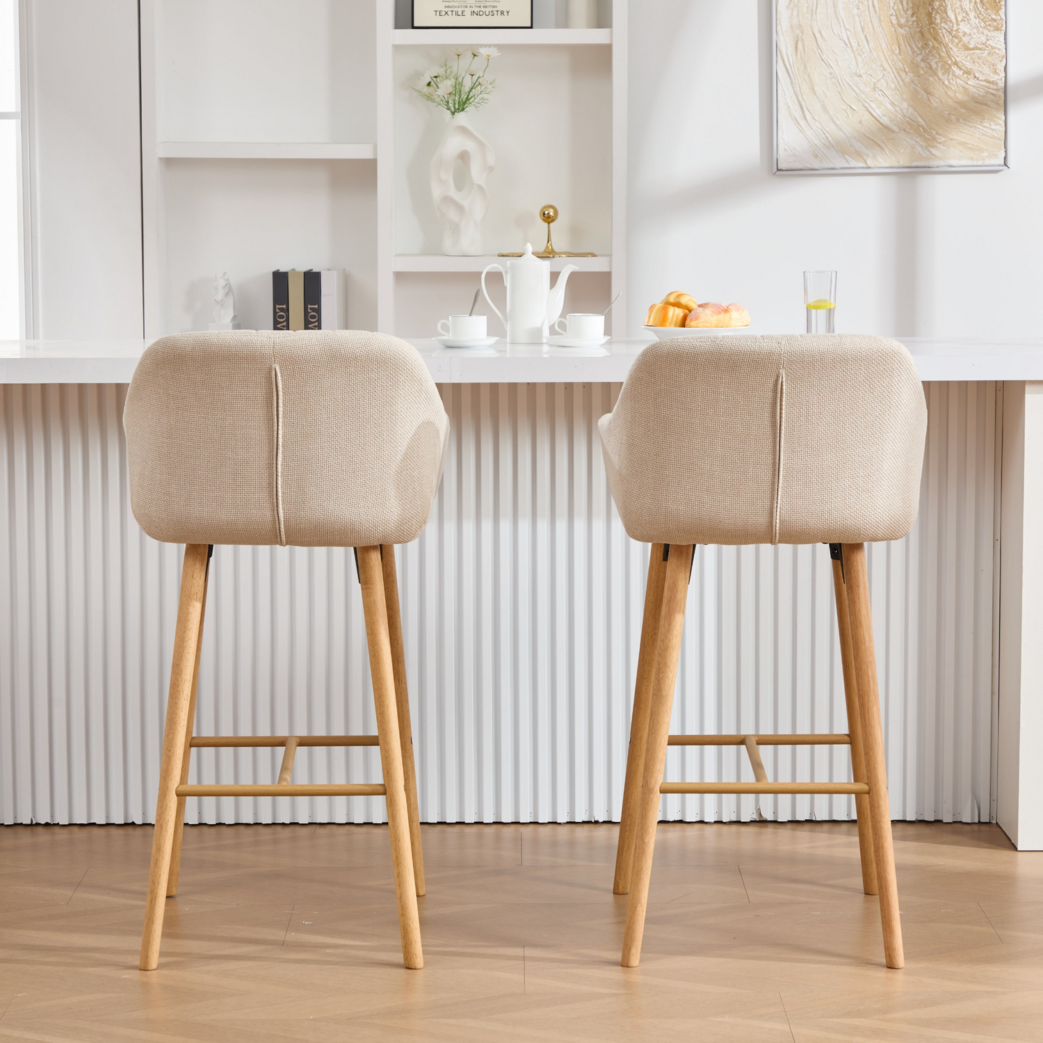 Modern linen upholstered bar stool with back, armrests, footrest, and solid wood legs, designed for stylish kitchen or bar area.