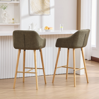 Modern linen upholstered bar stool with back, armrests, footrest, and solid wood legs, designed for stylish kitchen or bar seating.
