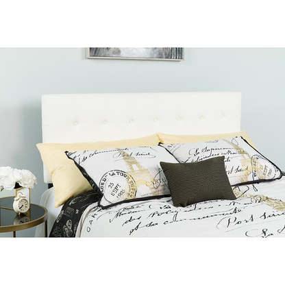 Tufted upholstered full-size headboard in white vinyl with button-tufted design, displayed in a bedroom setting.
