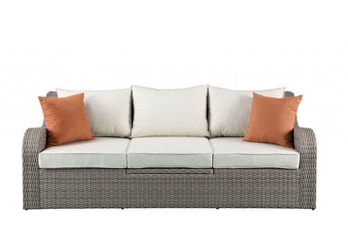 Gray wicker patio sectional and ottoman set by Jade, featuring comfortable outdoor furniture for garden or patio lounging.