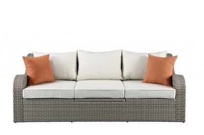 Gray wicker patio sectional and ottoman set by Jade, featuring comfortable outdoor furniture for garden or patio lounging.