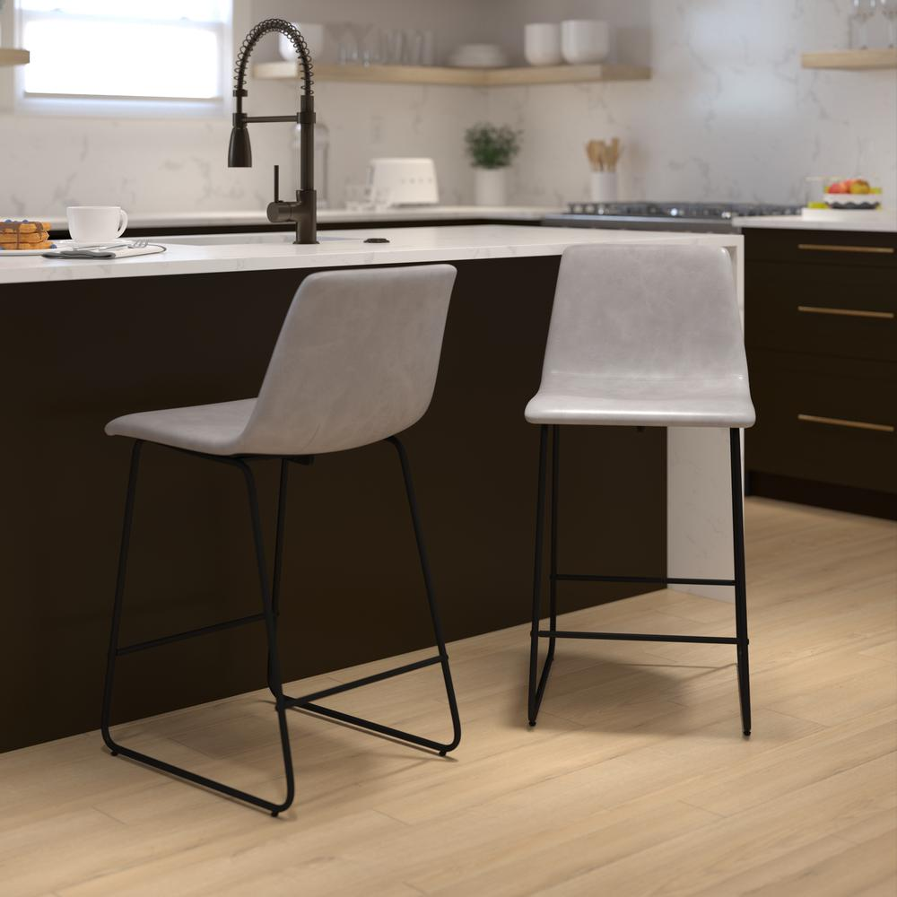 Set of two 24-inch Light Gray LeatherSoft counter height barstools with wooden legs and backrests, ideal for kitchen or bar seating.