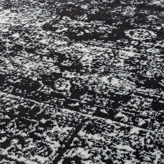 Distressed vintage Persian woven area rug with intricate patterns and warm tones, showcasing a textured, antique-inspired design.