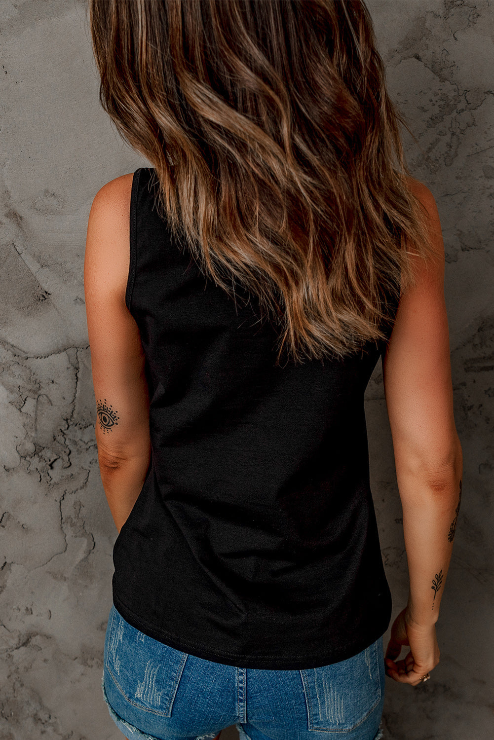 Black strappy hollow-out neck tank top by Harlequin Daisy, featuring a stylish design with cut-out details and slim straps.
