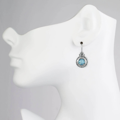 Silver drop earrings featuring blue topaz gemstones and intricate filigree floral design for women.