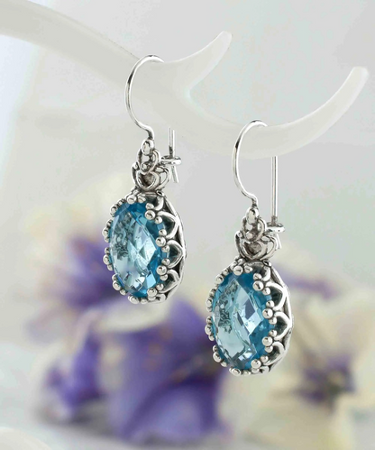 Silver drop earrings featuring blue topaz gemstones, filigree art design, and oval shape for women.