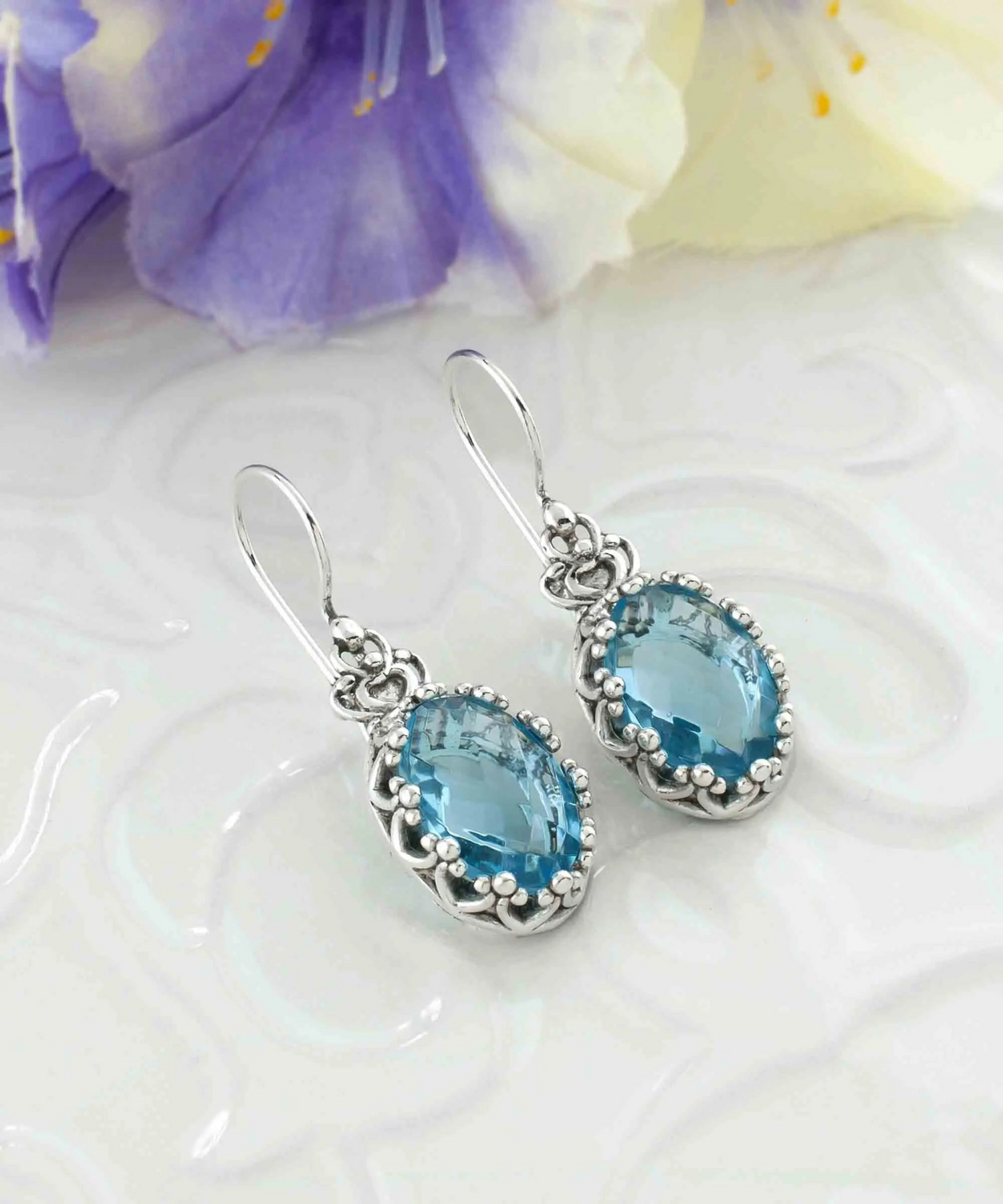 Silver drop earrings featuring filigree art, blue topaz gemstones, and a crown design for women.