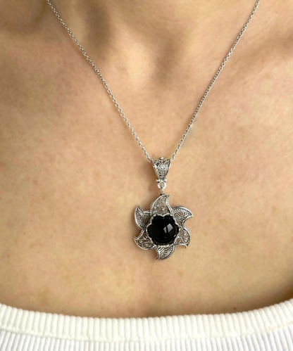 Sterling silver filigree lotus flower pendant with black onyx gemstone, elegant jewelry necklace with intricate design.