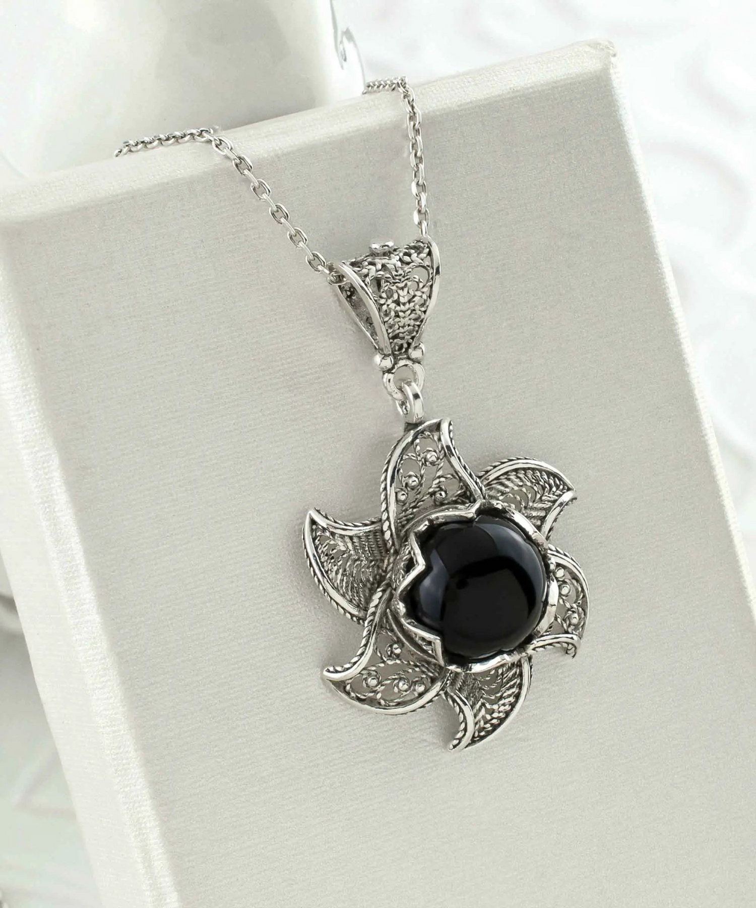 Sterling silver filigree lotus flower pendant with black onyx gemstone, detailed jewelry necklace, elegant and blossoming design.