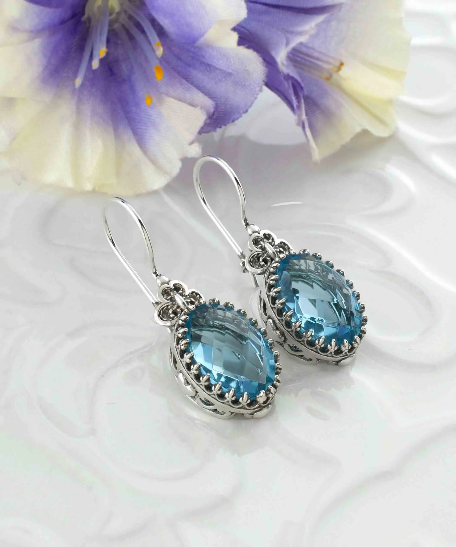 Silver oval drop earrings with filigree design and blue topaz gemstone heart detail for women, intricate jewelry by Start2Finish.