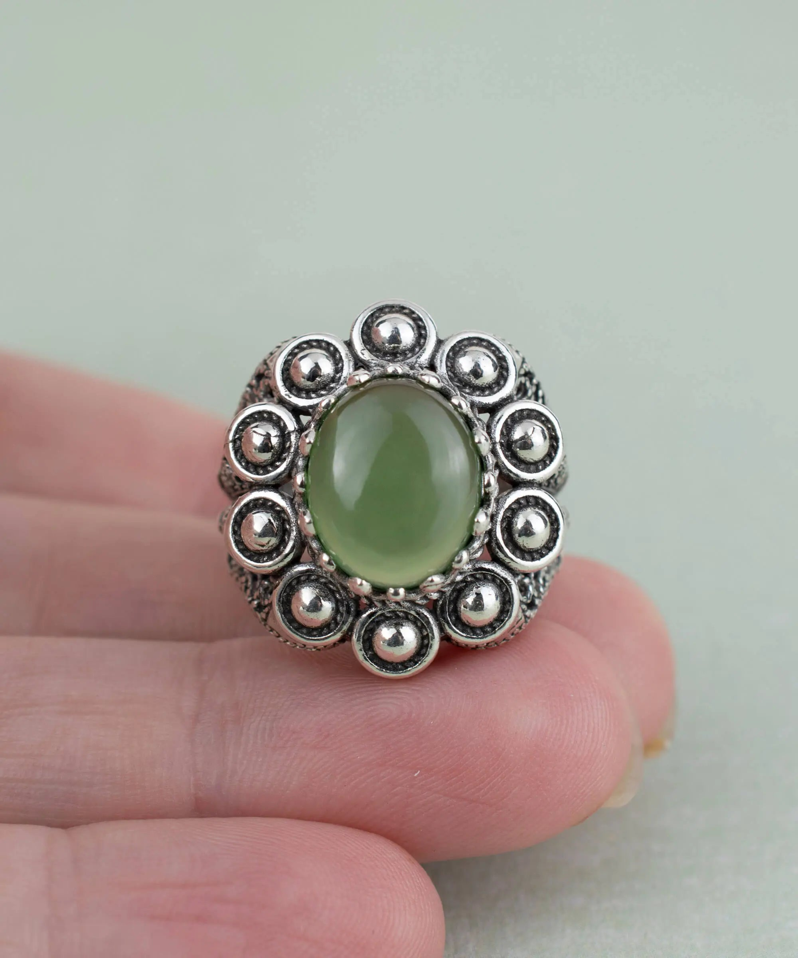 Filigree art serpentine gemstone women’s statement dome ring in jewelry, featuring intricate design and vibrant green stone.