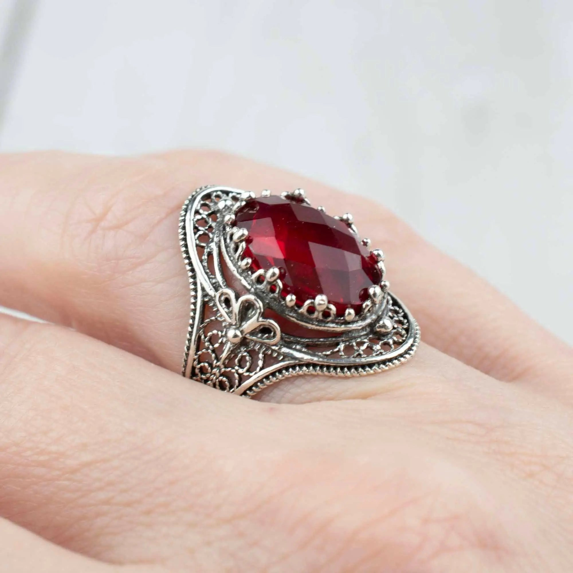 Silver woman’s statement ring featuring ruby quartz gemstone with intricate filigree design, crafted by Start2Finish jewelry brand.
