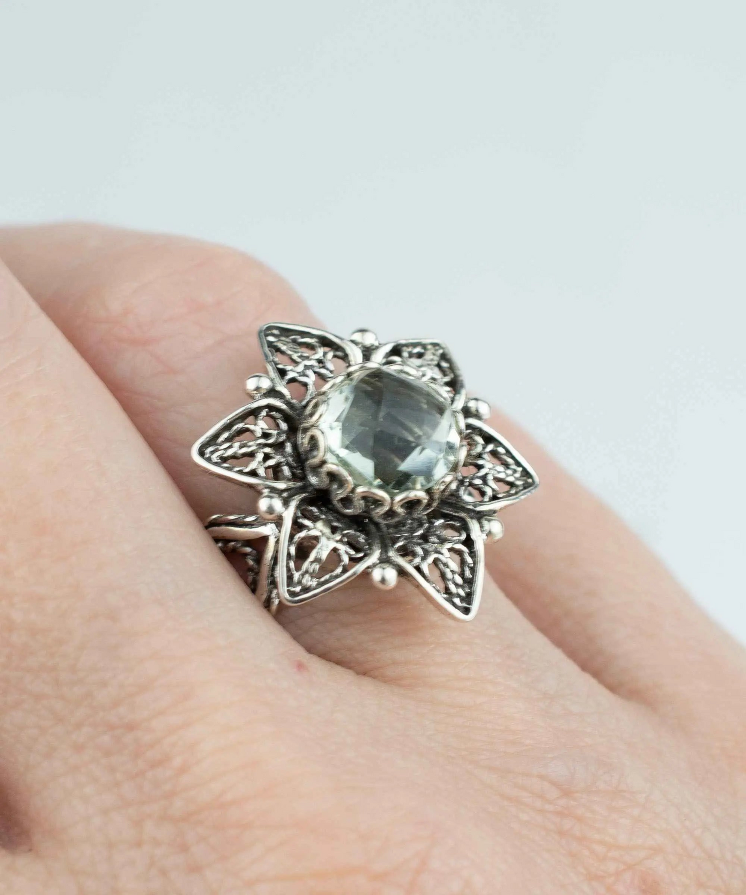 Silver cocktail ring featuring a filigree design with a prasiolite gemstone daisy flower, crafted by Start2Finish.
