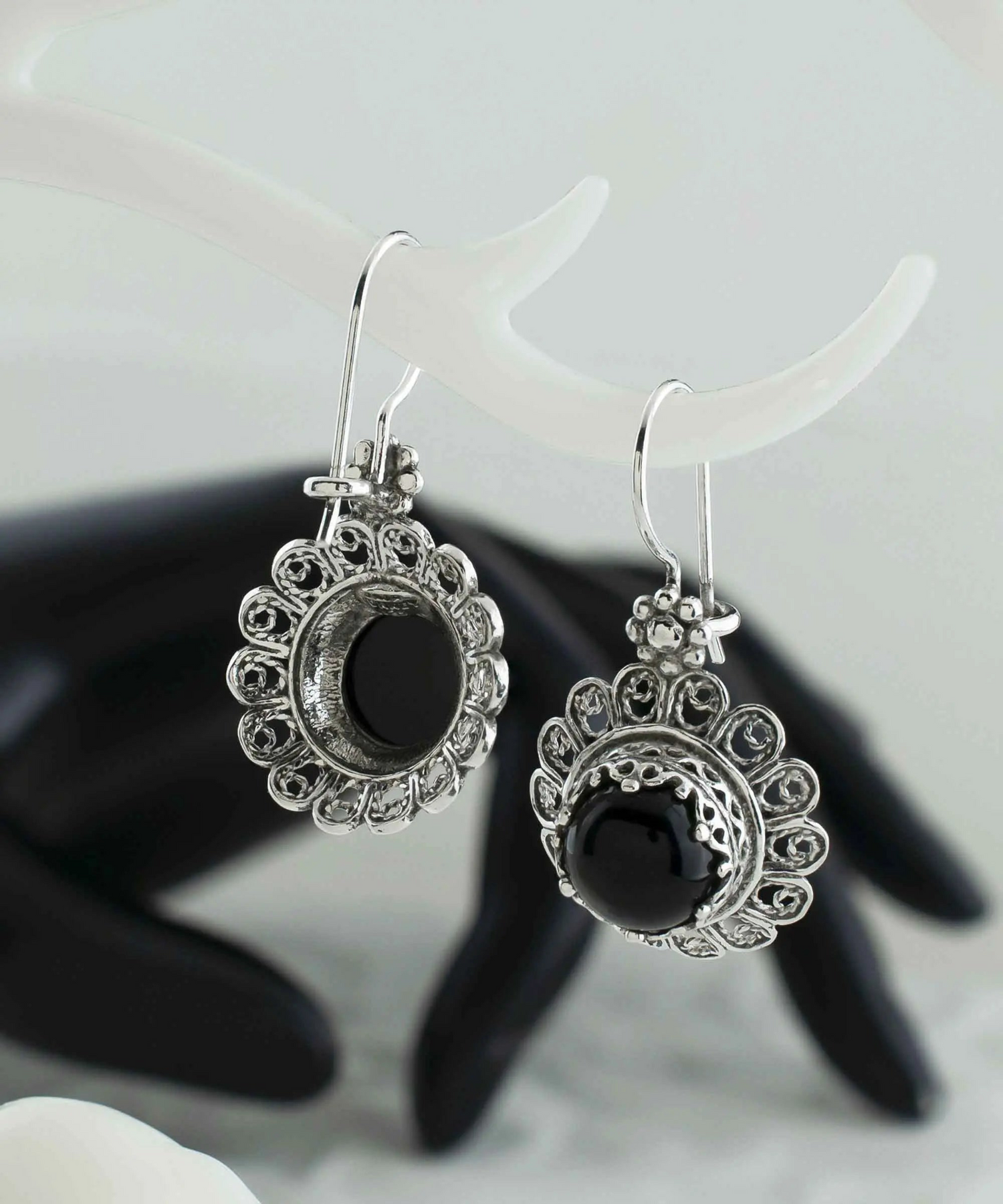 Silver drop earrings featuring black onyx gemstones with intricate filigree flower design for women.