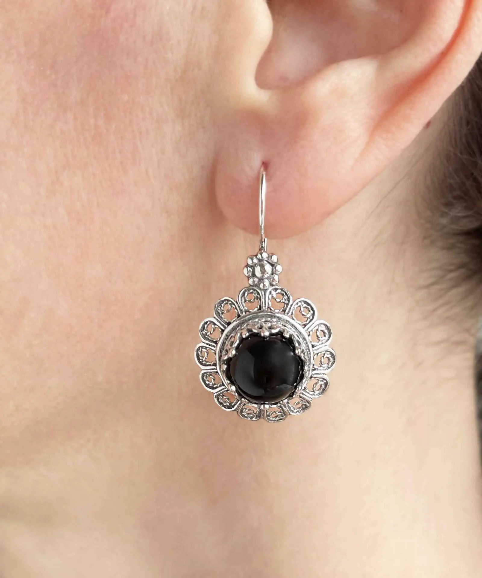 Silver drop earrings with filigree flower design and black onyx gemstones for women, featuring intricate jewelry craftsmanship.
