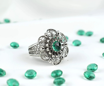 Silver statement ring with filigree art and emerald gemstone for women, featuring intricate jewelry design.