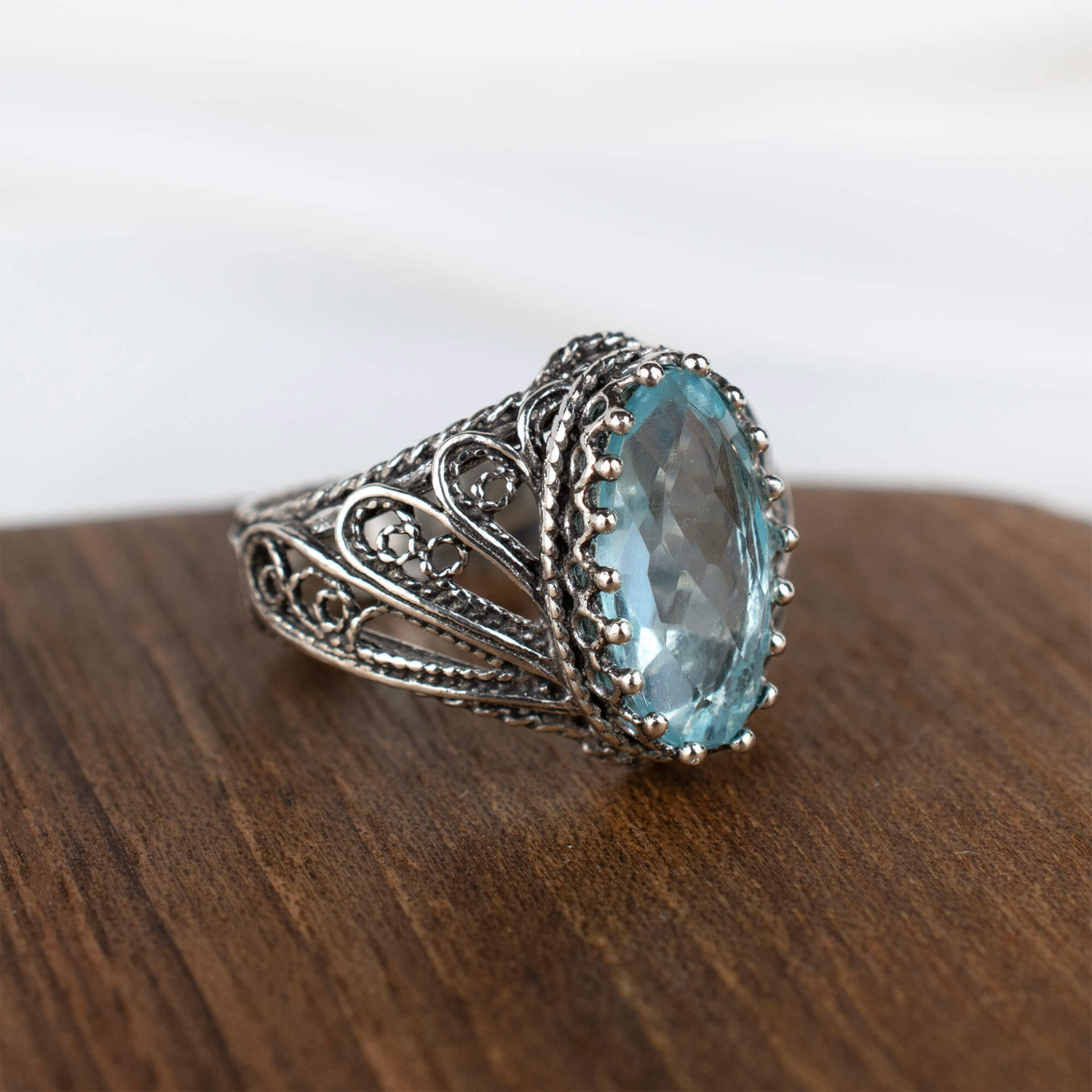 Silver cocktail ring with filigree art blue topaz gemstone and angel design, elegant jewelry for women.