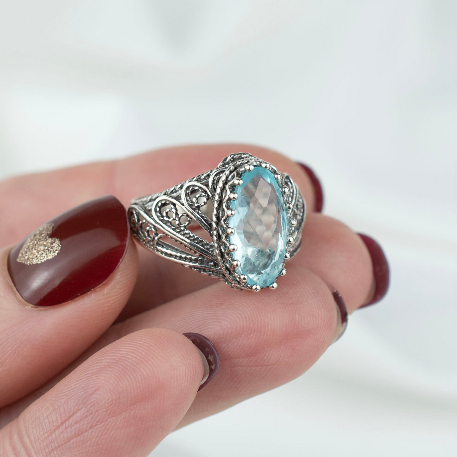 Silver cocktail ring featuring a filigree angel design with a blue topaz gemstone, crafted by Start2Finish for women.