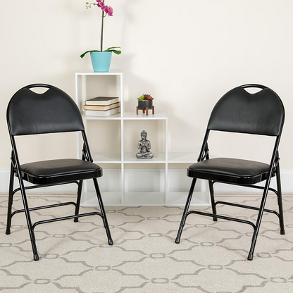Two black vinyl folding chairs with triple-braced metal frames and easy-carry handles, designed for durable, portable furniture.
