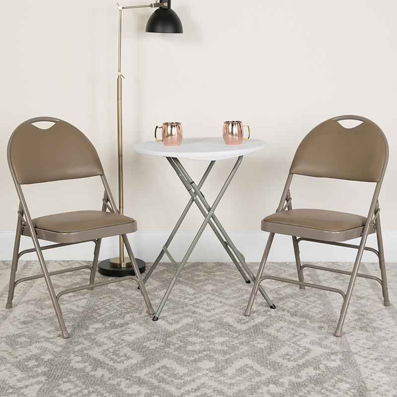Two beige HERCULES Series triple-braced vinyl metal folding chairs with easy-carry handles from Start2Finish.