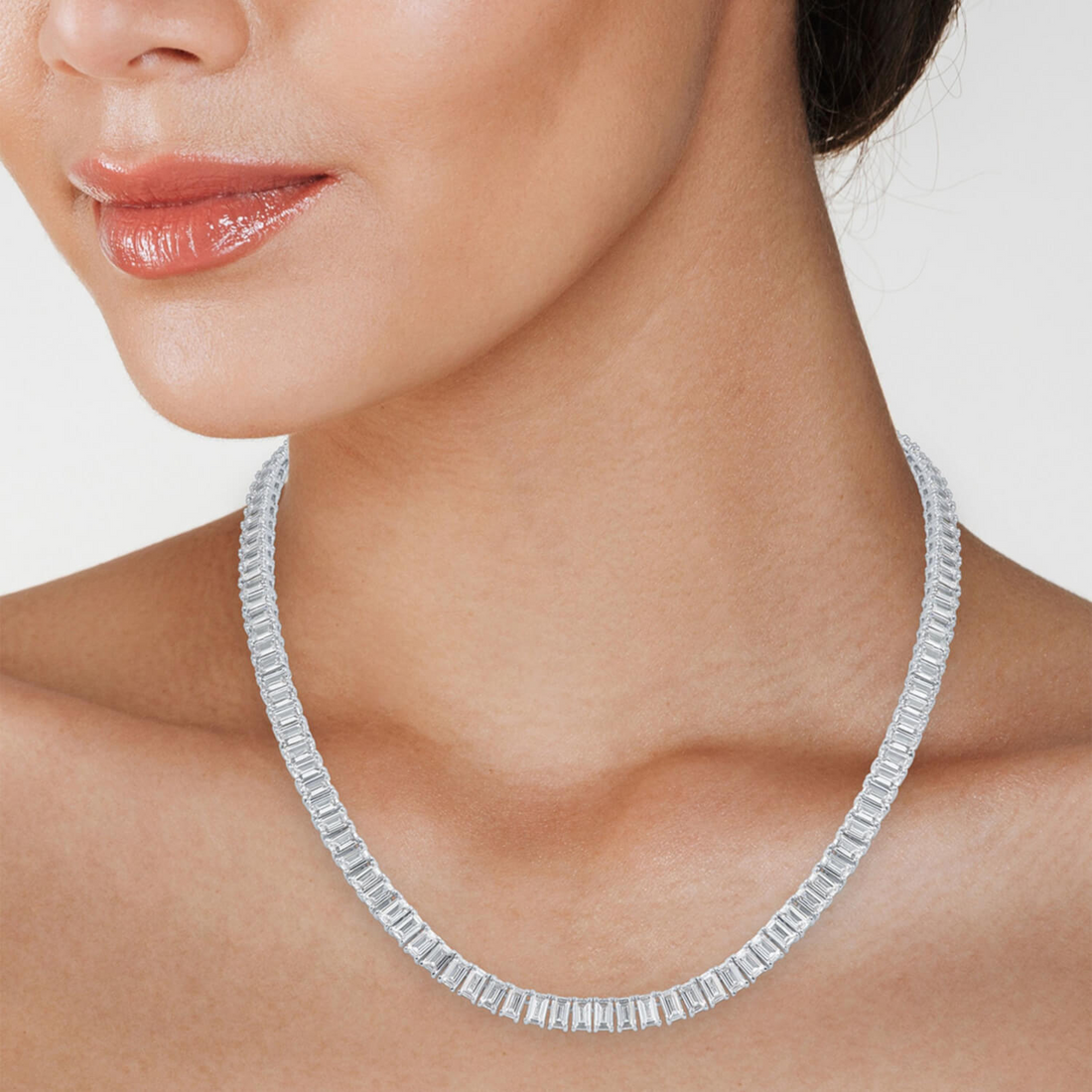 18-inch emerald-cut created moissanite tennis necklace in 14K gold overlay with 30 carats total weight, shown on a display stand.