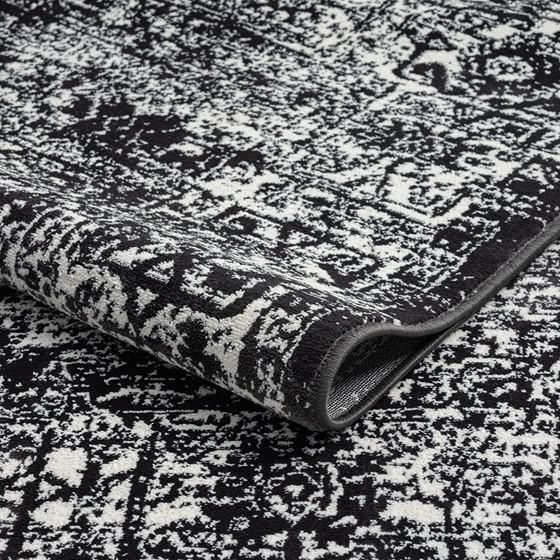 Distressed vintage Persian woven area rug with intricate patterns and warm tones, showcasing rustic, handcrafted craftsmanship.