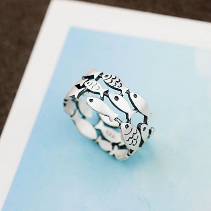 Silver fish ring by Fuchsia Molly featuring a detailed fish design, crafted in sterling silver, shown on a neutral background.