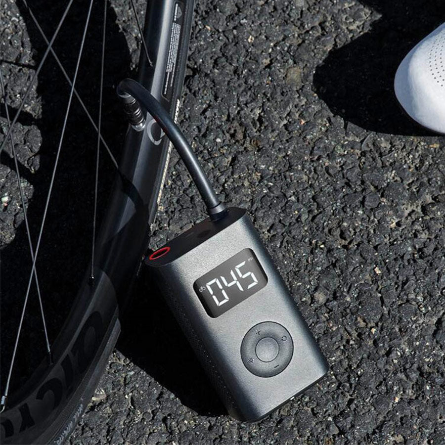 Maroon Asteria portable car air pump, compact household mini pump for automotive inflation, shown on white background.