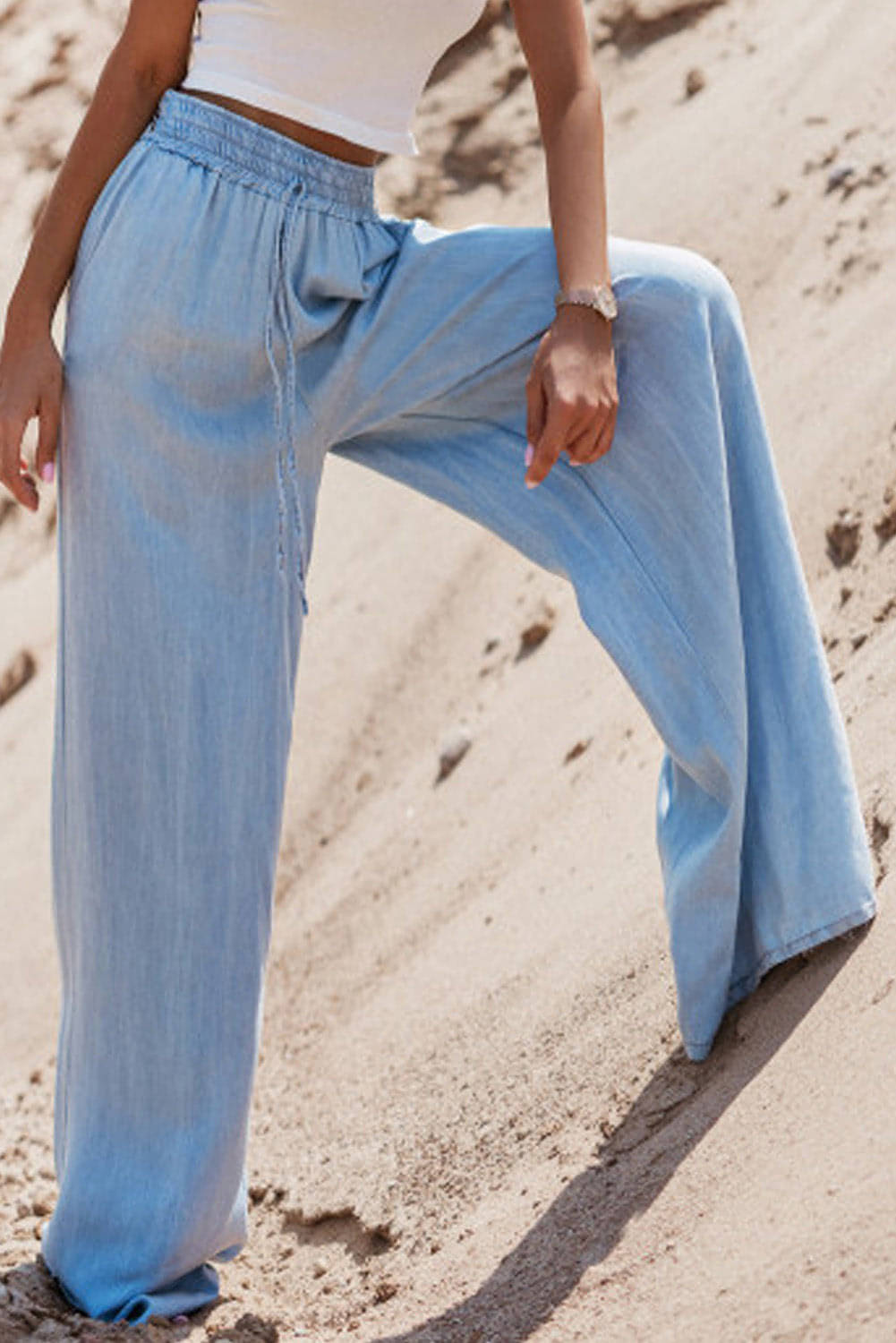 Carmine Juneberry Myosotis high waist wide leg denim pants with drawstring waist and relaxed fit on a model.