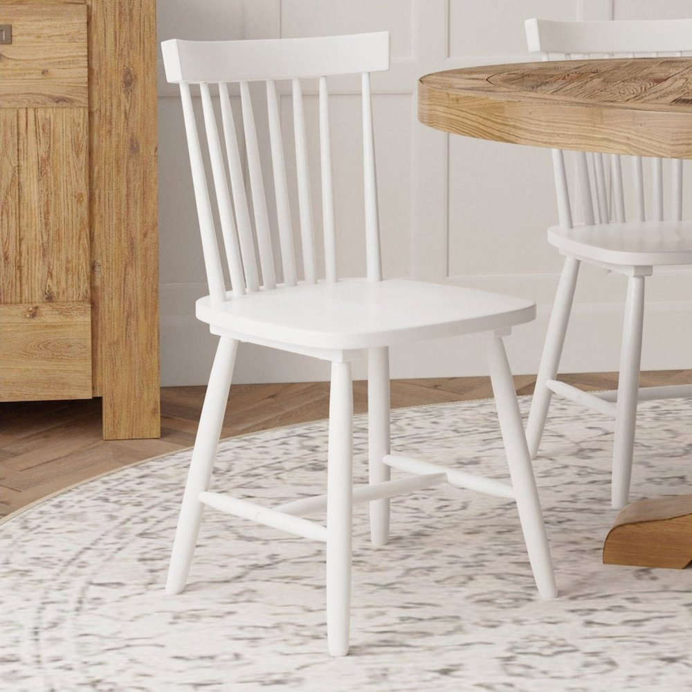 Set of 2 white Lyra side chairs from Start2Finish, featuring modern furniture design with sleek wooden legs and cushioned seats.