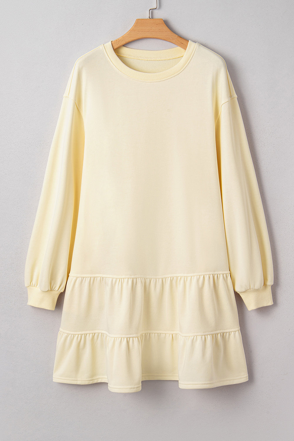 Solid tiered ruffle hem long sleeve dress by Byzantium Bay, featuring a flowing silhouette and layered ruffle details.