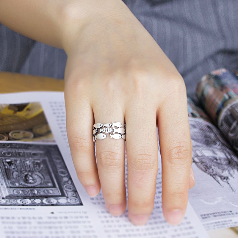 Silver fish-shaped ring from Fuchsia Molly, showcasing intricate design and shiny finish on a plain background.