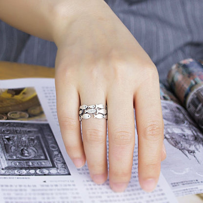 Silver fish-shaped ring from Fuchsia Molly, showcasing intricate design and shiny finish on a plain background.