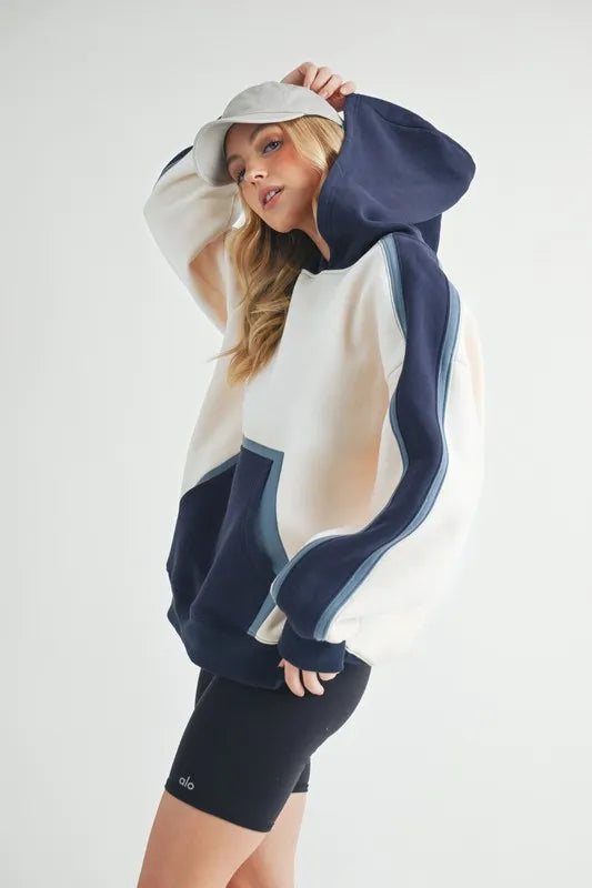 Aemi + Co color block kangaroo pocket hoodie in vibrant shades, featuring a cozy design perfect for casual wear.