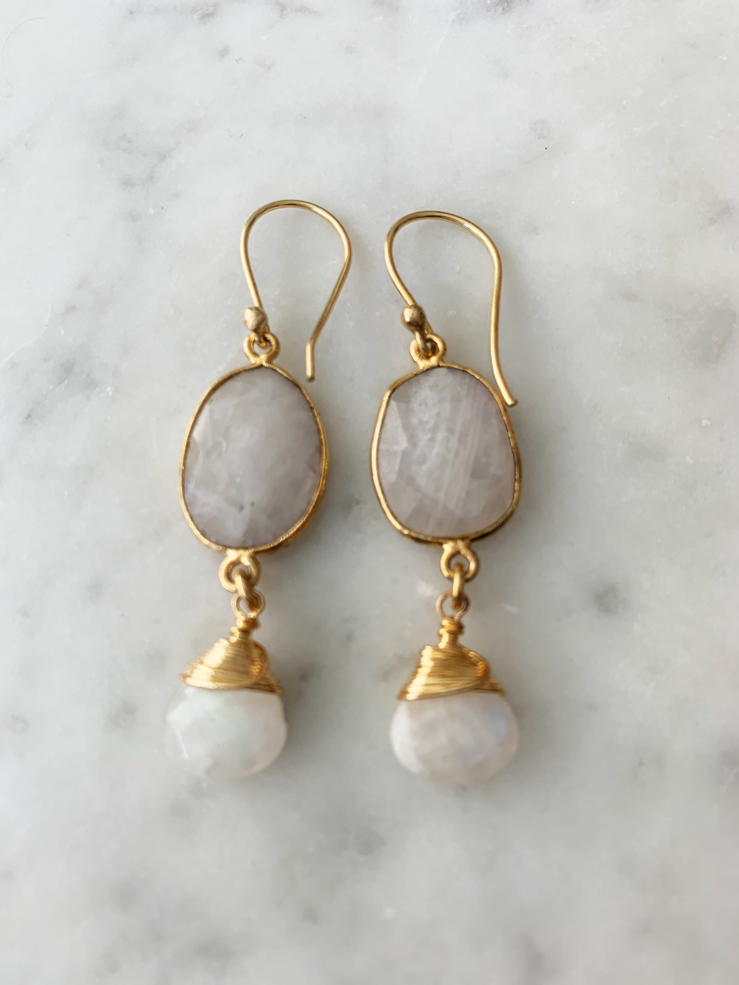 Victoria earrings in moonstone jewelry featuring elegant silver hooks and shimmering moonstone cabochons.