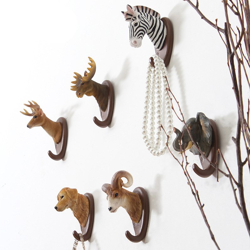 Fuchsia Molly animal wall hook mounted on a wooden wall, decorative home and garden accessory with a playful animal design.