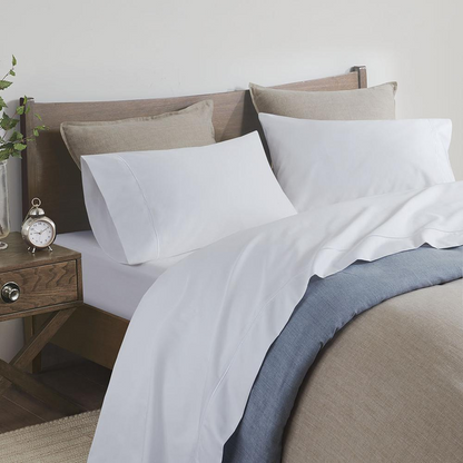 Start2Finish Pima Cotton Sheet Set with smooth, white fabric, featuring neatly folded sheets and pillowcases on a bed.