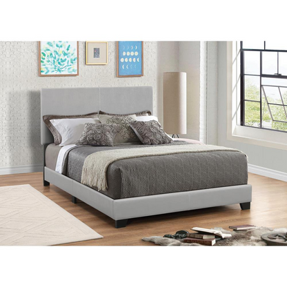 Start2Finish Dorian upholstered queen panel bed in grey with a padded headboard and sleek wooden frame, shown in a modern bedroom setting.
