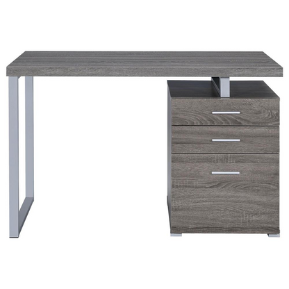 Weathered grey Brennan 47-inch 3-drawer office computer desk by Start2Finish, showing sturdy wood surface and sleek drawer handles.